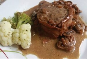Filet miñon (lomo de res envuelto en tocineta y bañado en salsa de hongos)