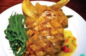 Pechuga rellena de frutas con salsa de queso rosa y almendras.