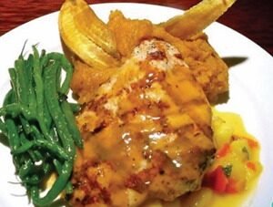 Pechuga rellena de frutas con salsa de queso rosa y almendras.